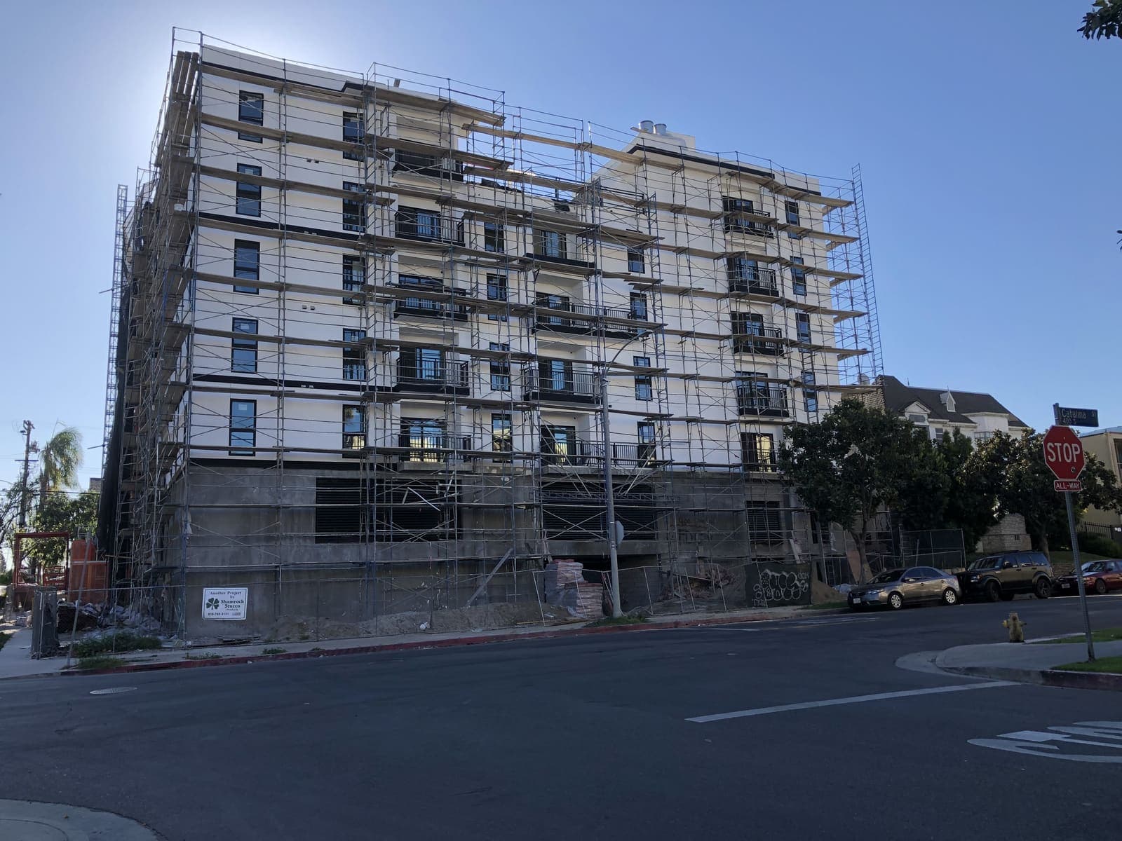 Six-story residential building under construction with full scaffolding