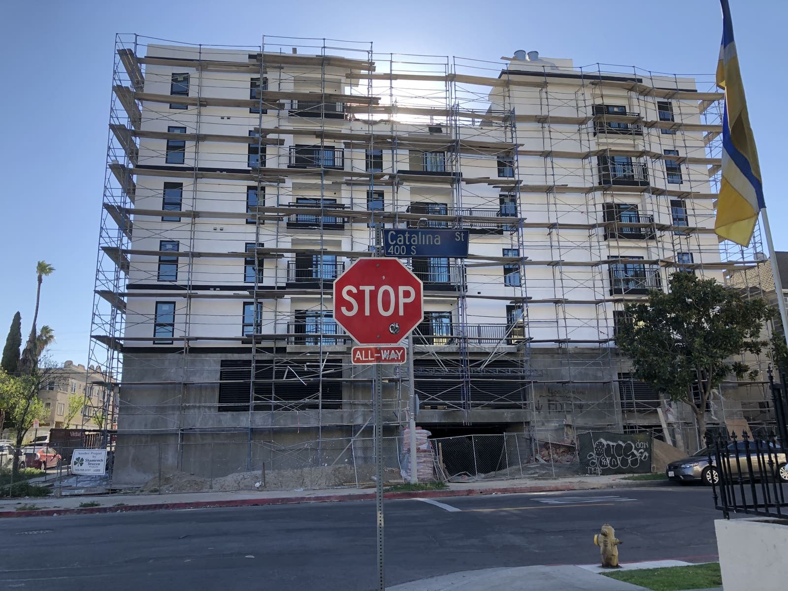 Multi-story building exterior on Catalina Street with scaffold and stop sign in foreground