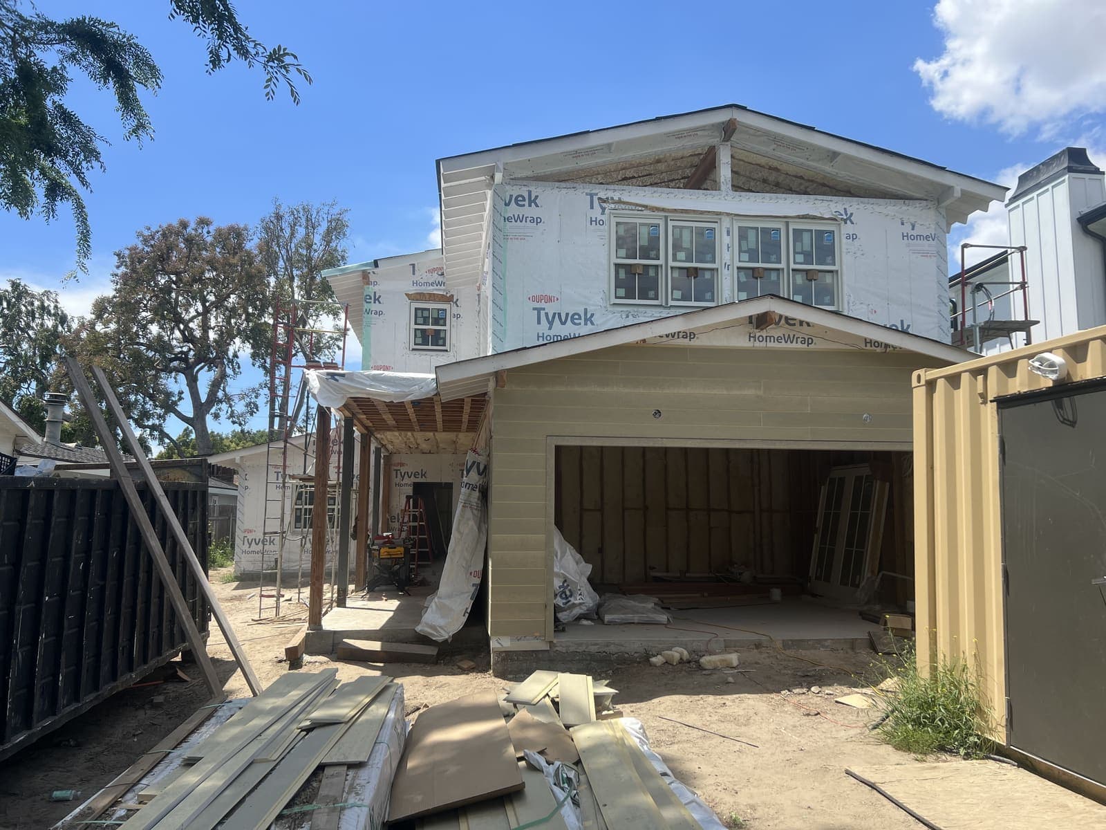 Two-story residential under construction with Tyvek house wrap and open garage