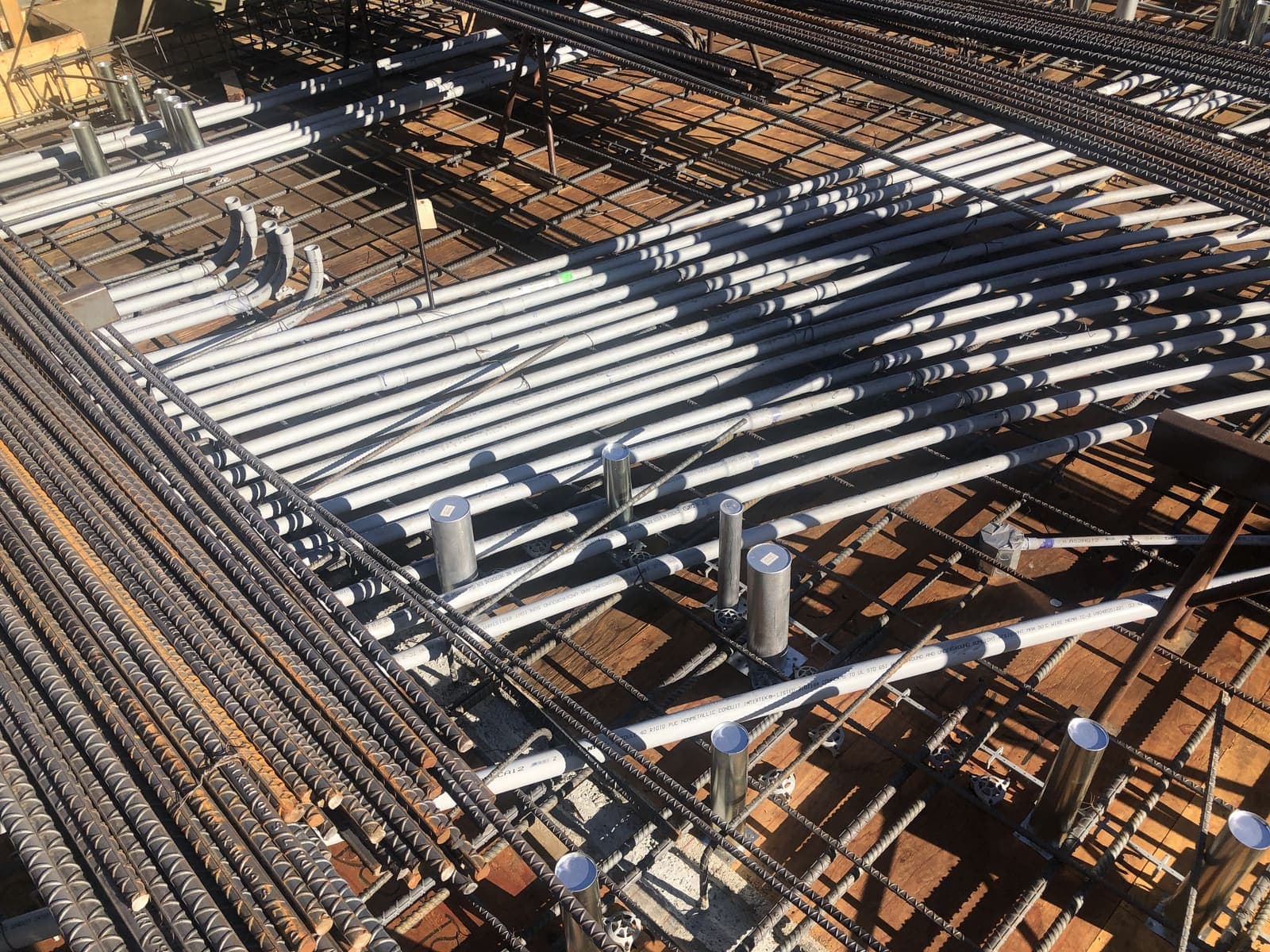 EMT conduit run through a rebar mat before a concrete pour