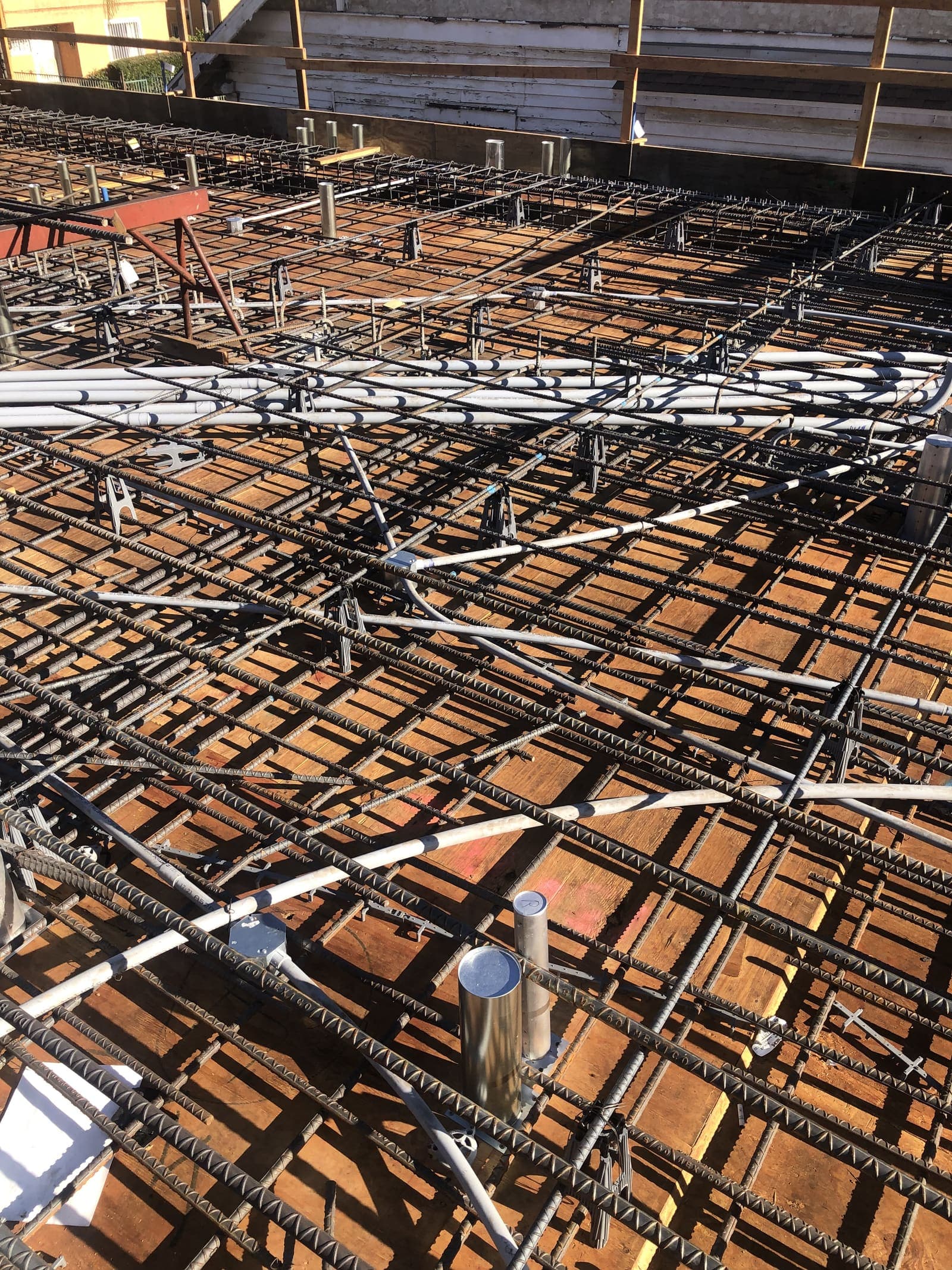 Overhead view of an elevated deck with rebar mat and EMT conduit runs