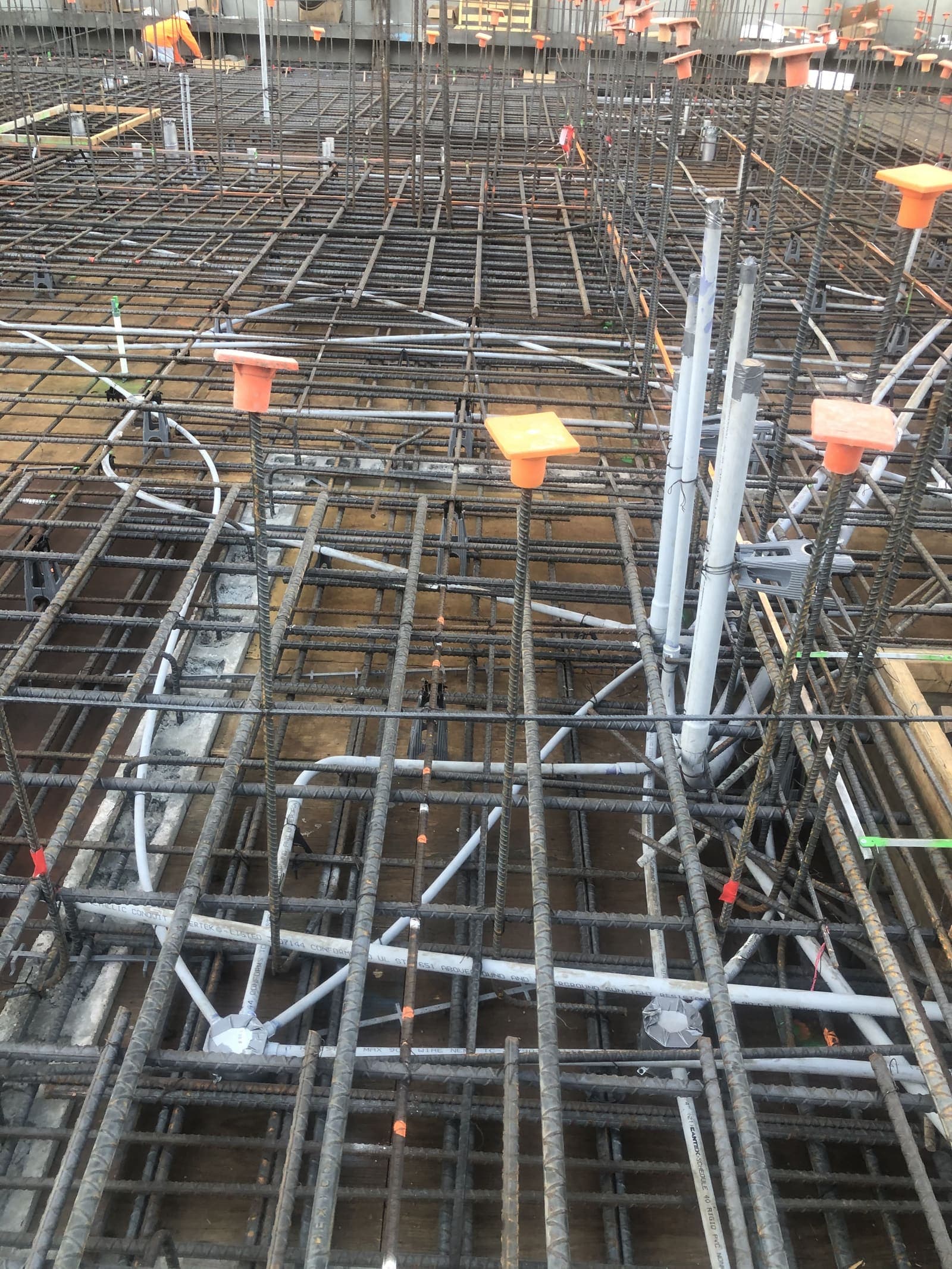 Slab rebar with EMT conduit risers and stub-ups before pour