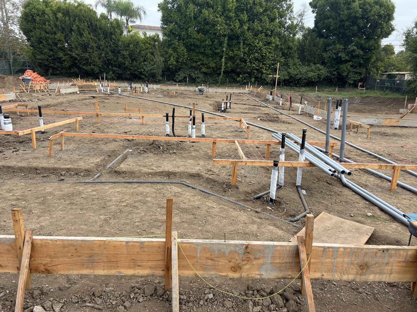 Residential slab pre-pour with formwork and rough conduit stub-ups