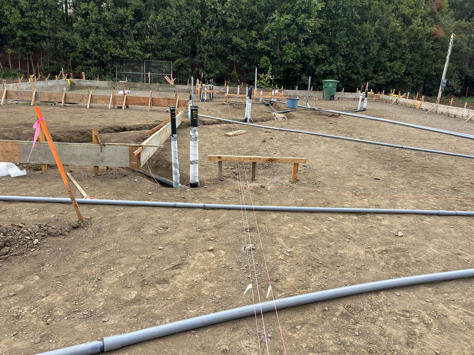 Single-family slab with underground PVC conduit runs laid across dirt